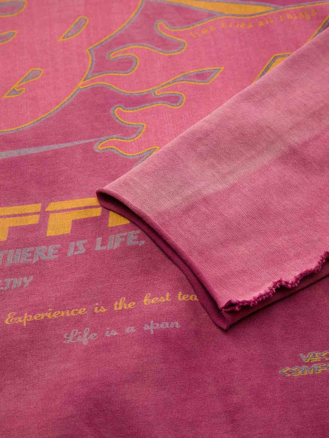 Zoomed-in texture of TALISHKO's washed-edge long sleeve T-shirt with vibrant graphics.