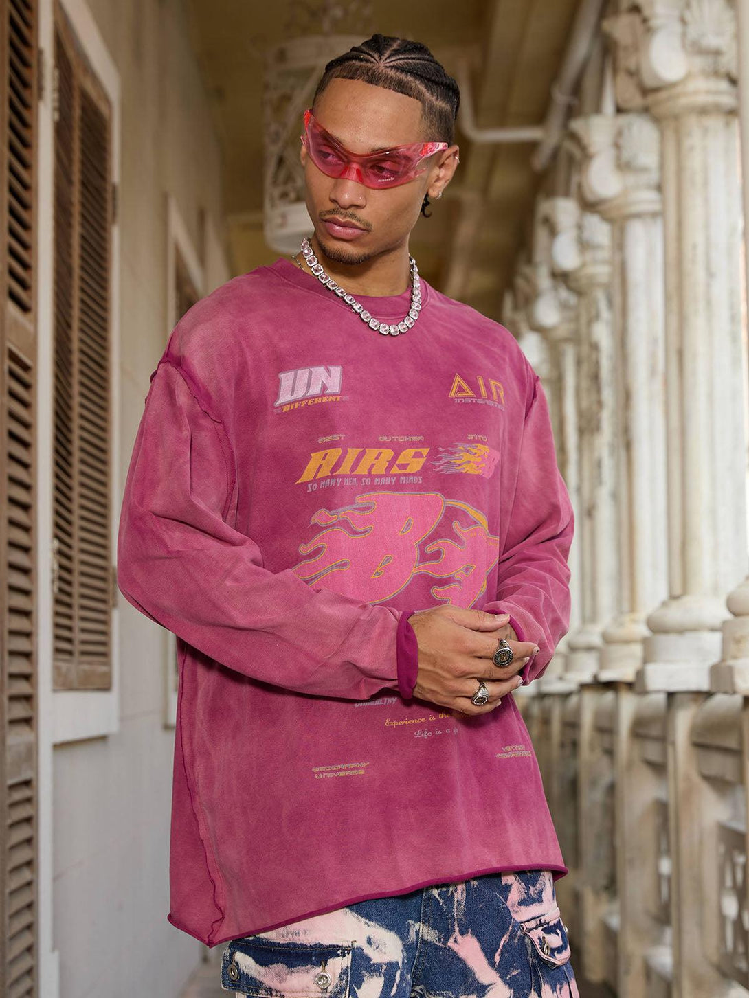 Model in a rose washed-edge long sleeve T-shirt by TALISHKO, styled with bold graphics.