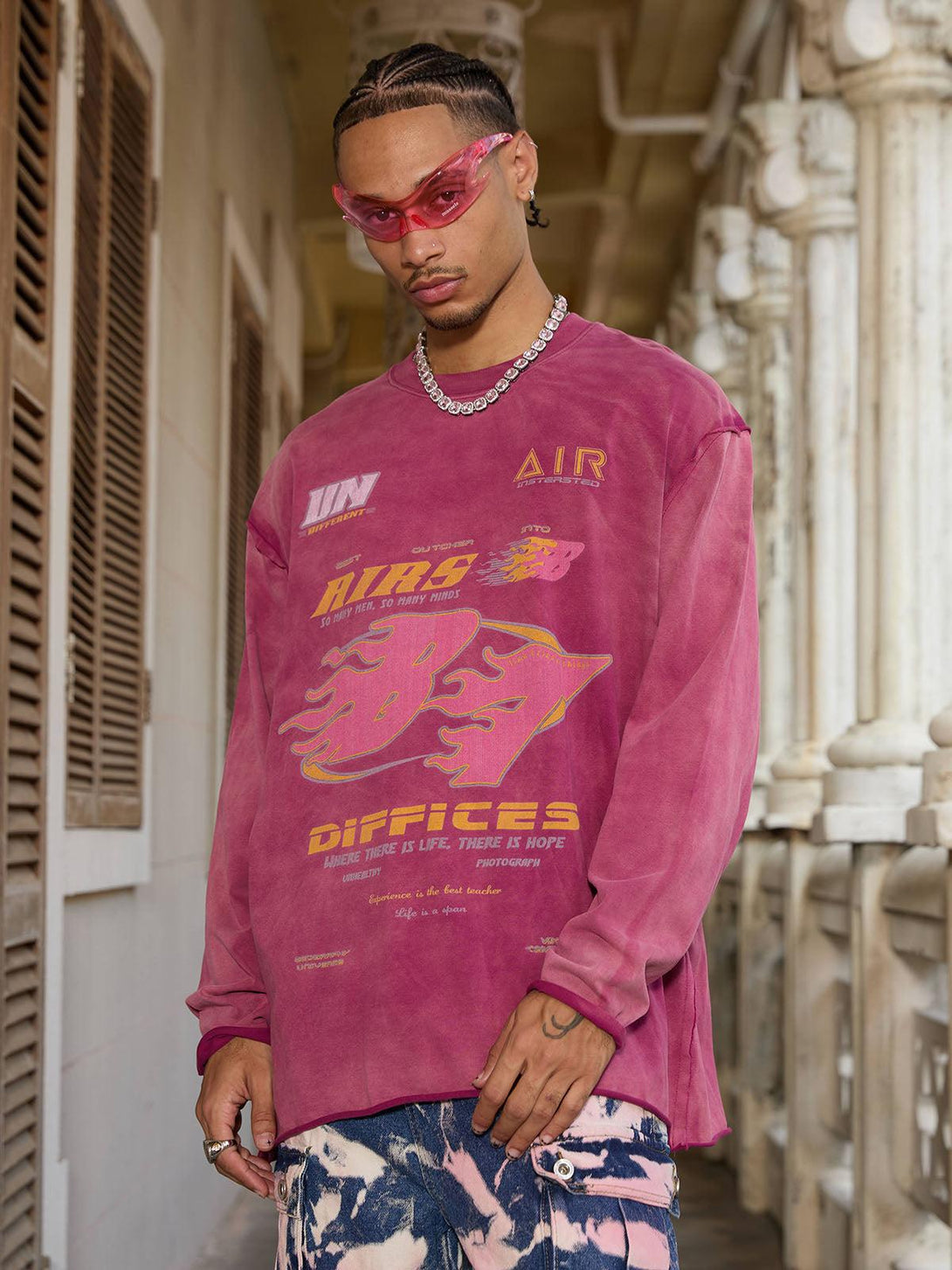 Model in a washed-edge long sleeve T-shirt by TALISHKO, accented with vibrant graphics.