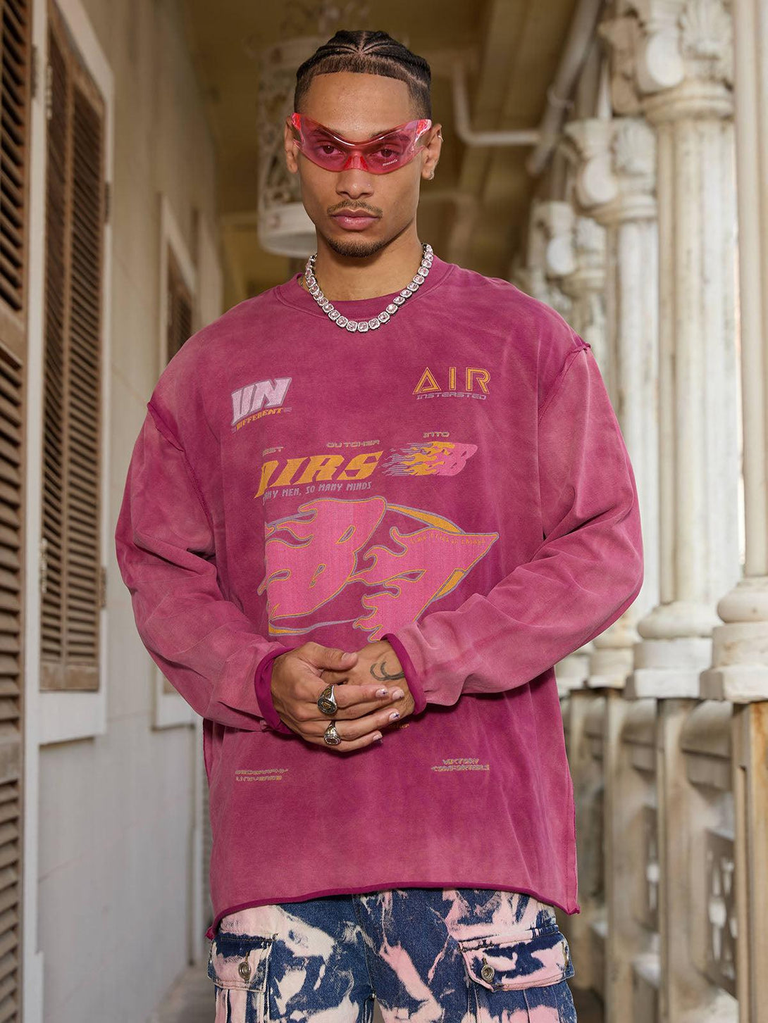 Model wearing a vibrant washed-edge long sleeve T-shirt by TALISHKO, styled with bold graphics.