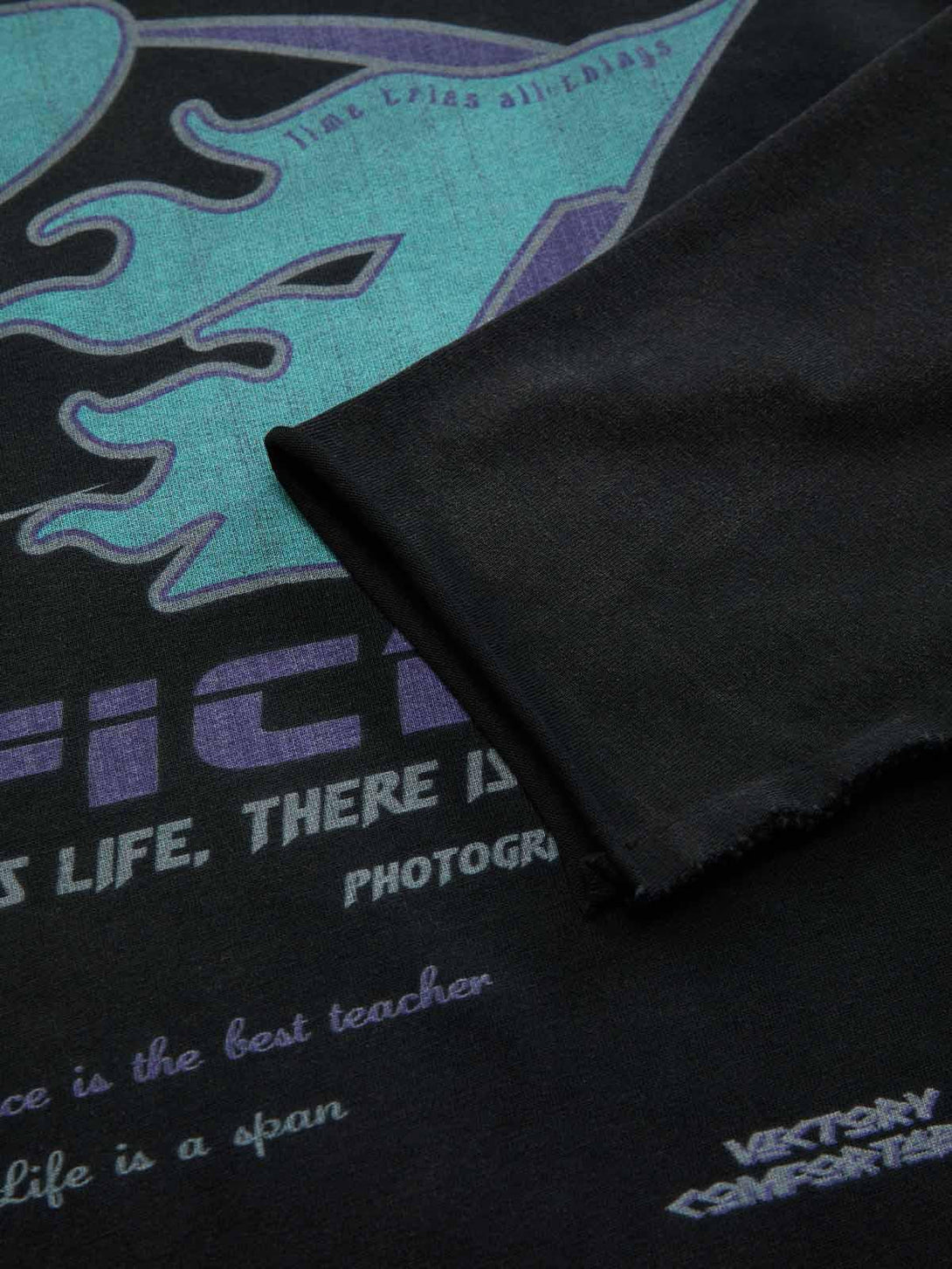 A tight crop highlighting TALISHKO's washed-edge long sleeve T-shirt with unique graphic design.