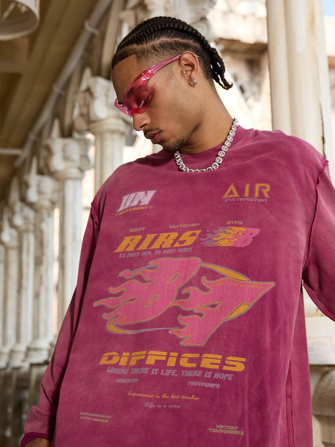 Model wearing a washed-edge long sleeve T-shirt by TALISHKO, featuring vibrant graphics and style.