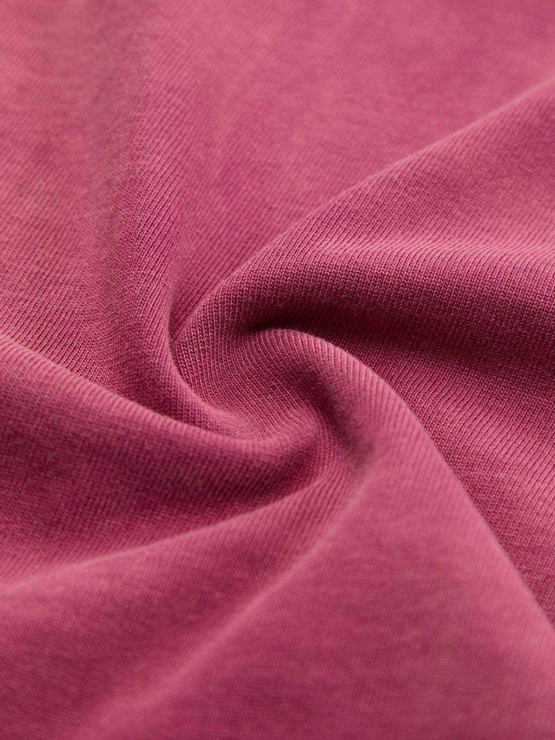 A detailed view of the washed-edge long sleeve T-shirt fabric by TALISHKO, highlighting texture.