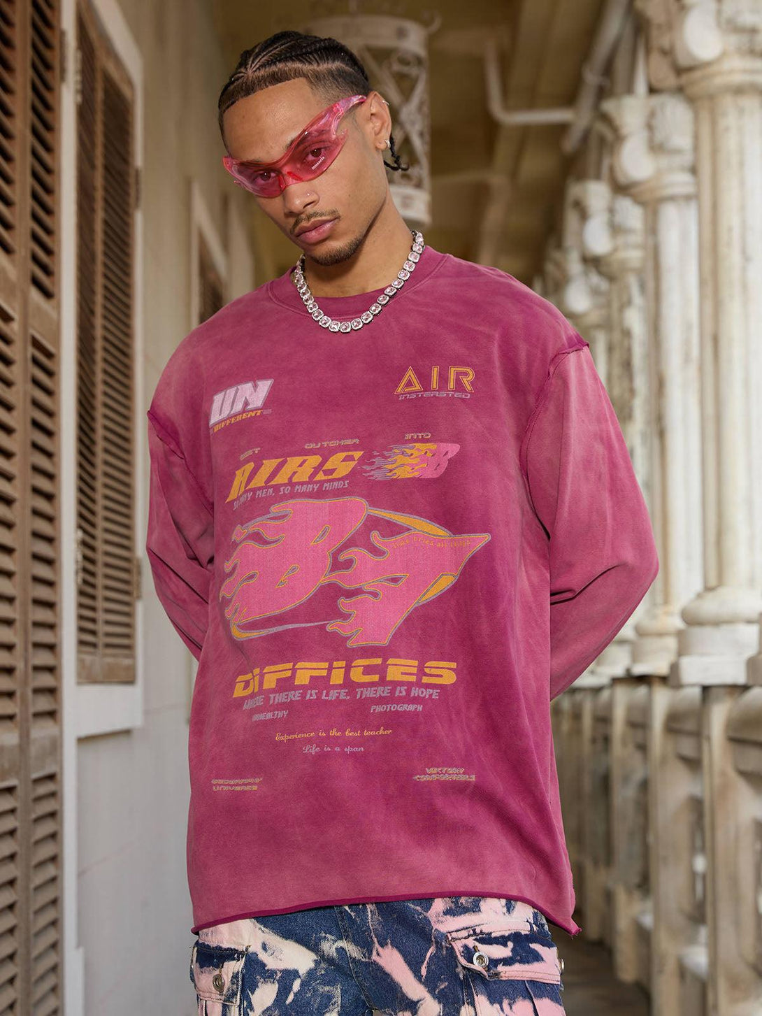 Model in a washed-edge long sleeve T-shirt by TALISHKO, featuring bold graphics and unique style.