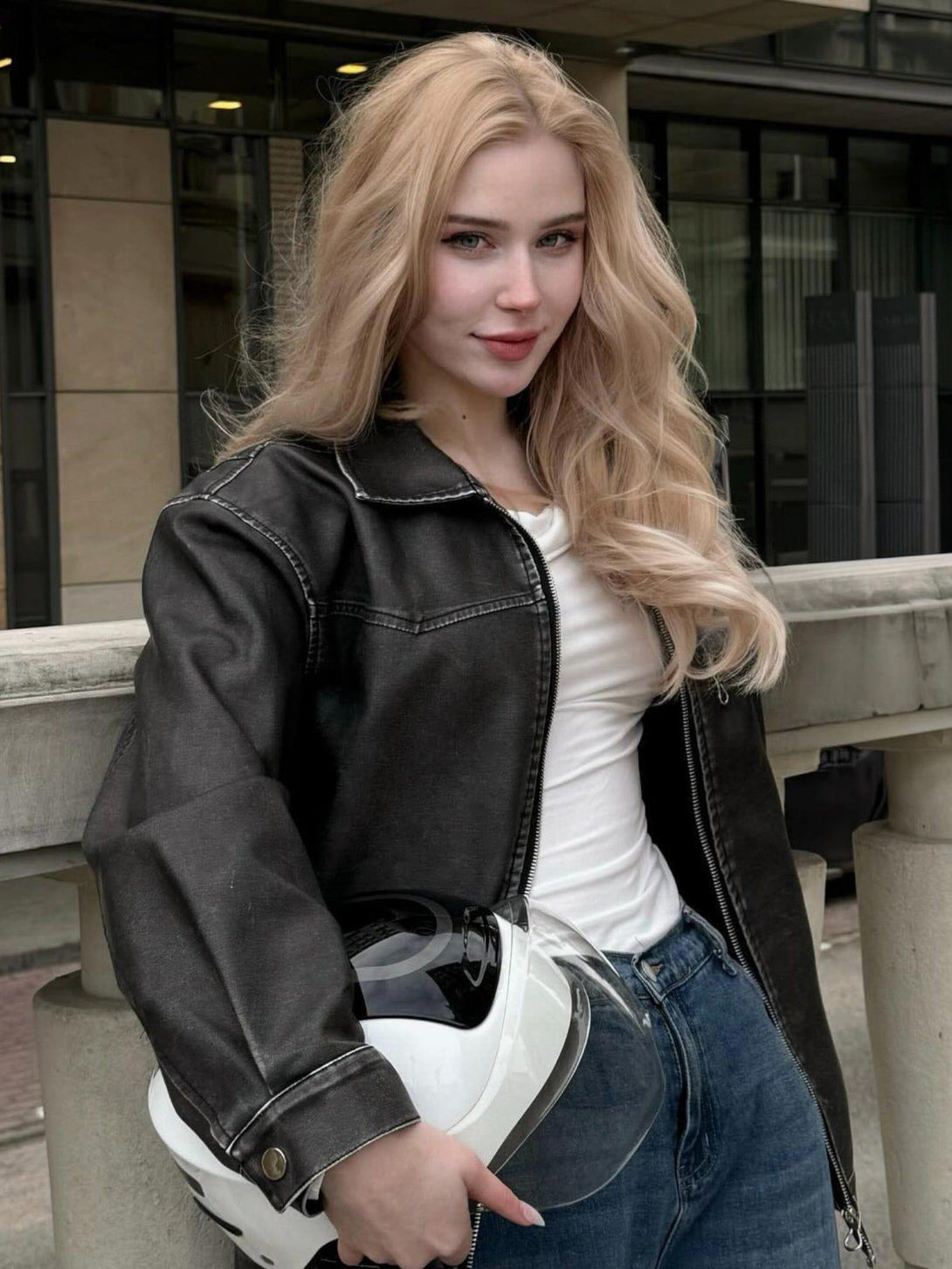 Model wearing a washed faux leather jacket by TALISHKO, paired with denim for a chic urban look.