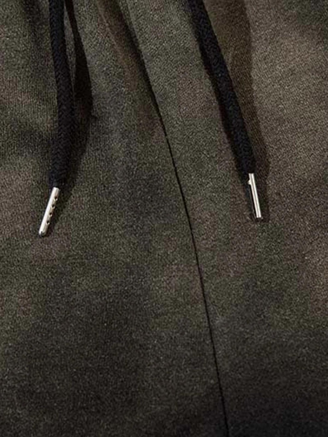 A close-up of TALISHKO washed gradient sweatpants, focusing on drawstring details and texture.