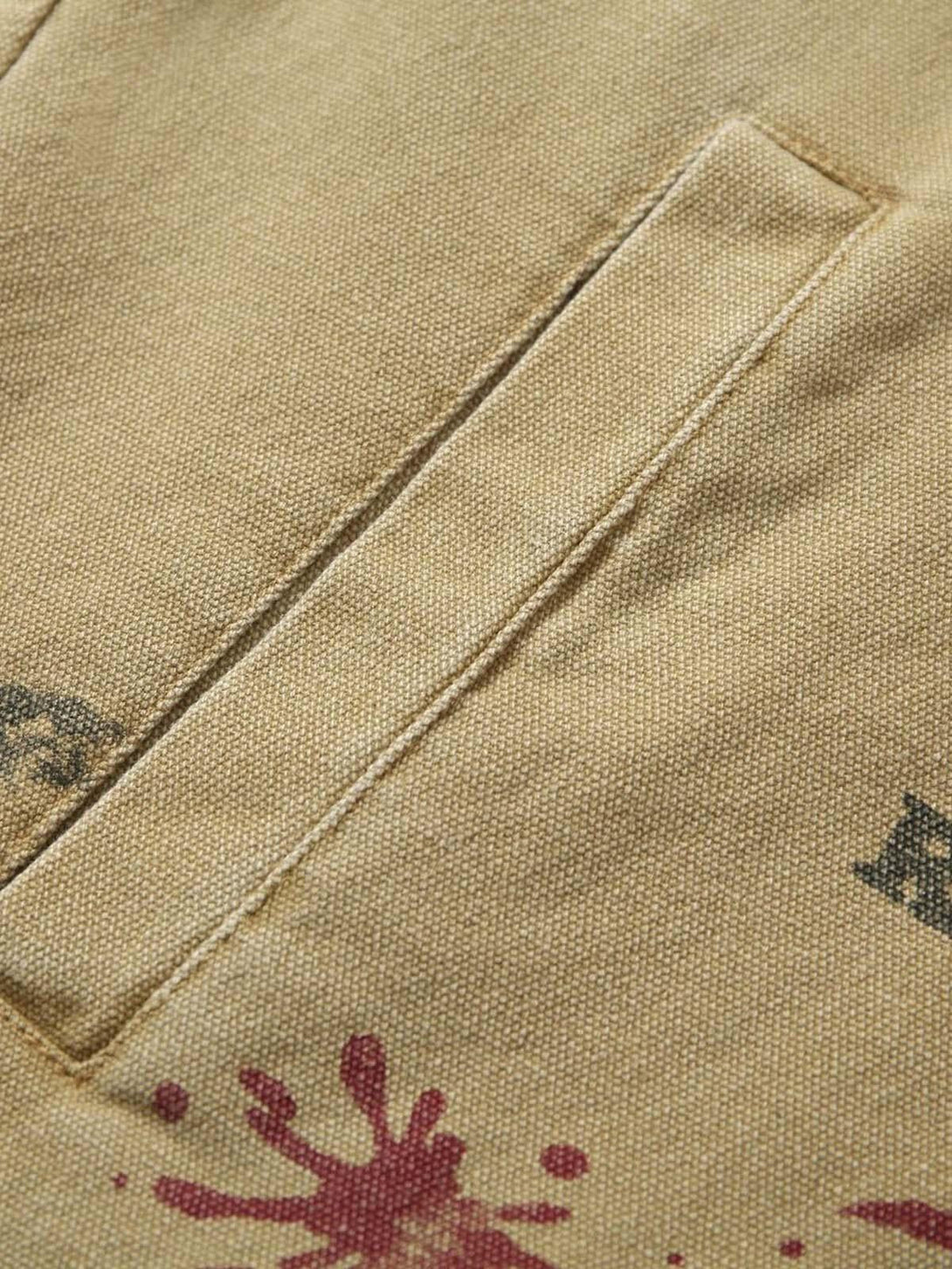Detailed fabric and stitching of TALISHKO's workwear jacket, featuring graffiti accents.