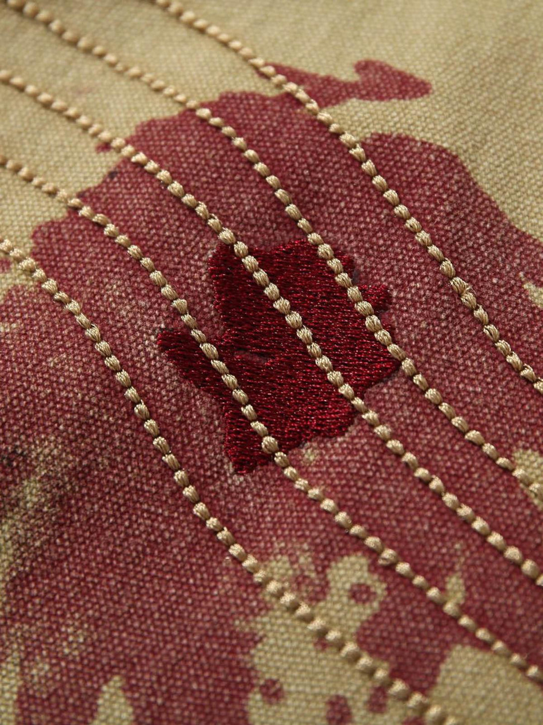 Intricate stitching detail on TALISHKO's workwear jacket, highlighting bold graffiti accents.
