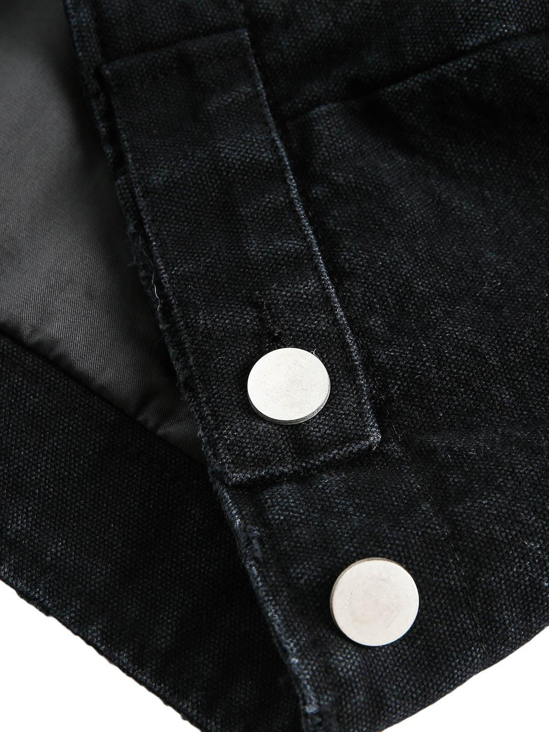 A tight crop highlighting TALISHKO denim jacket's button detail and textured fabric.
