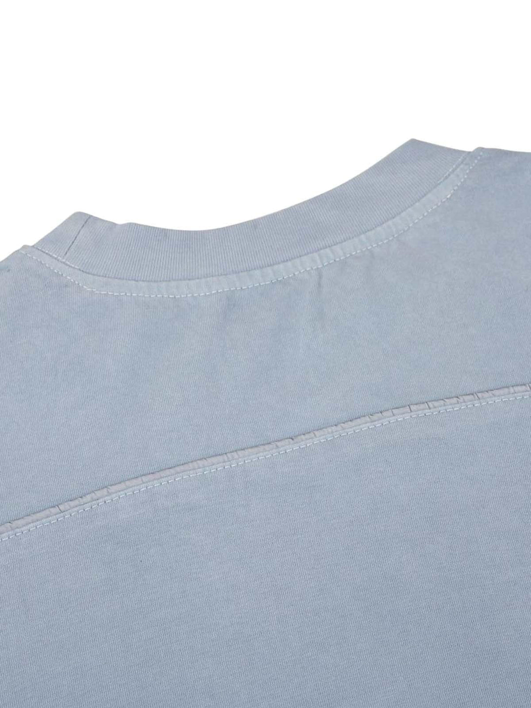 A detailed view of the light blue jersey fabric by TALISHKO, highlighting welt stitching.