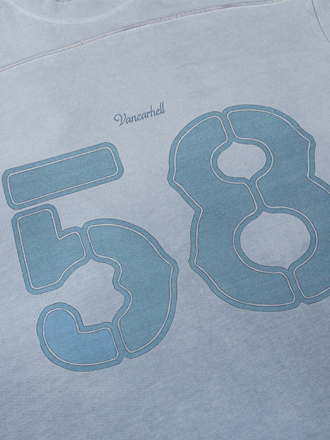 Close-up of blue washed jersey T-shirt by TALISHKO, featuring number 58 and welt stitching.