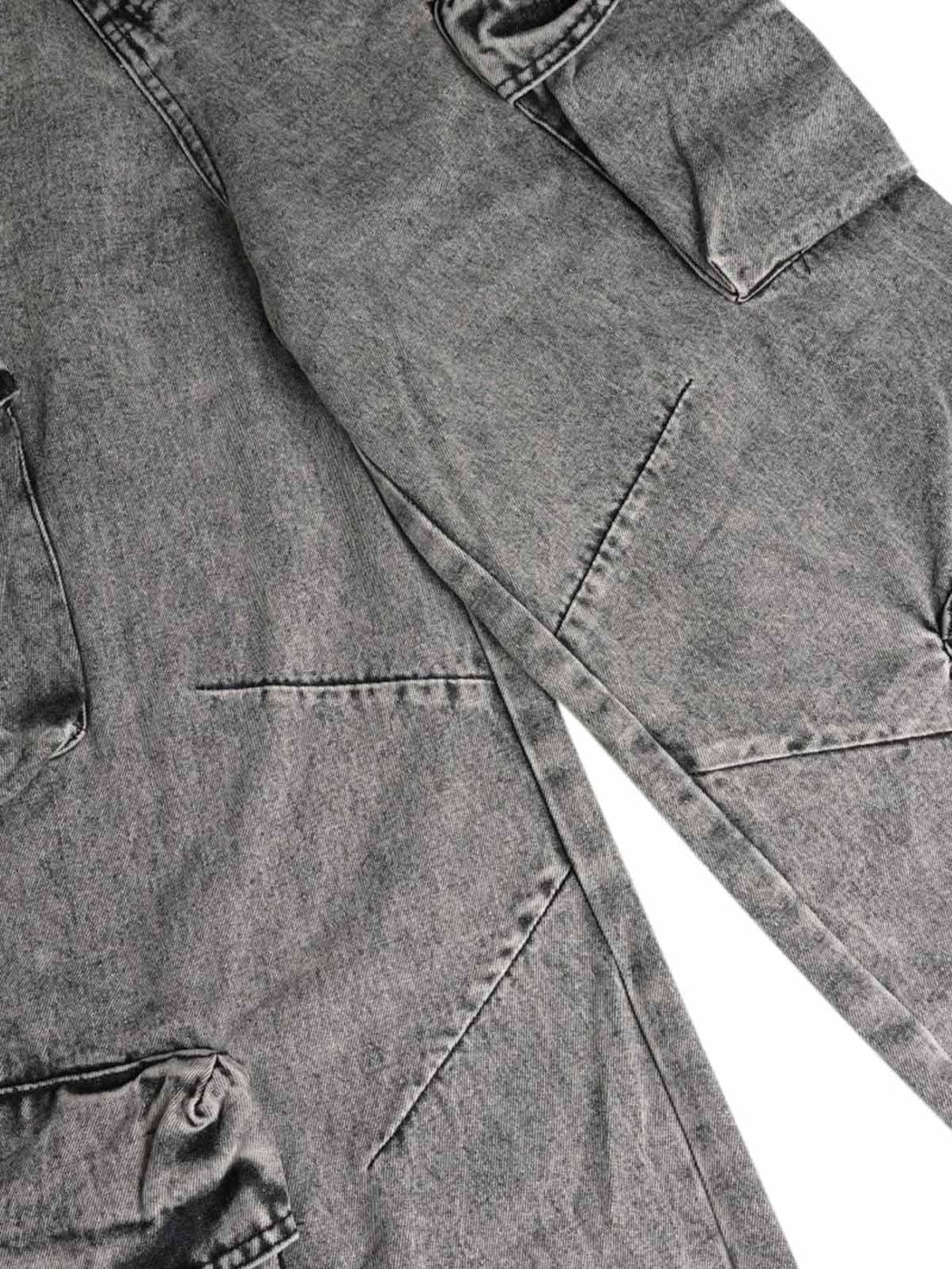 Intricate look at washed cargo jeans by TALISHKO, featuring multi-pocket details and unique texture.