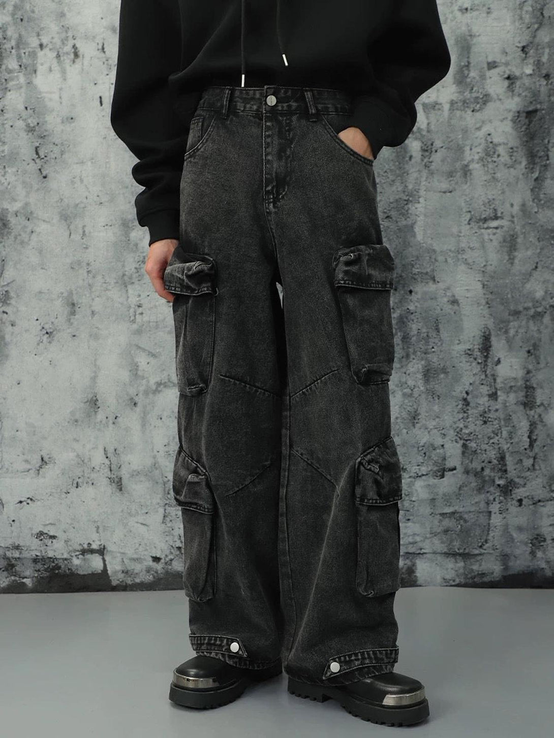 Model wearing black washed cargo jeans by TALISHKO, featuring multiple pockets for edgy style.