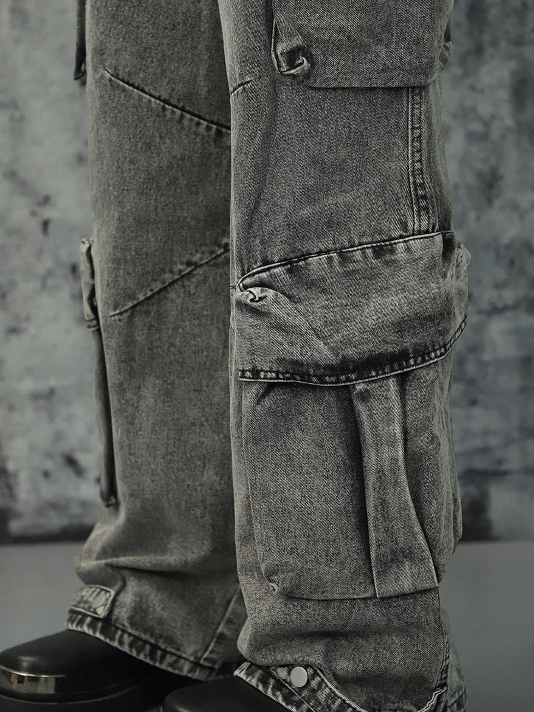 Detailed view of gray washed cargo jeans by TALISHKO, highlighting multi-pocket design.