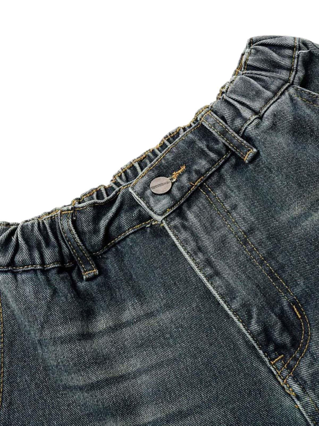 A detailed view of the washed denim cargo jorts' waist and stitching by TALISHKO.