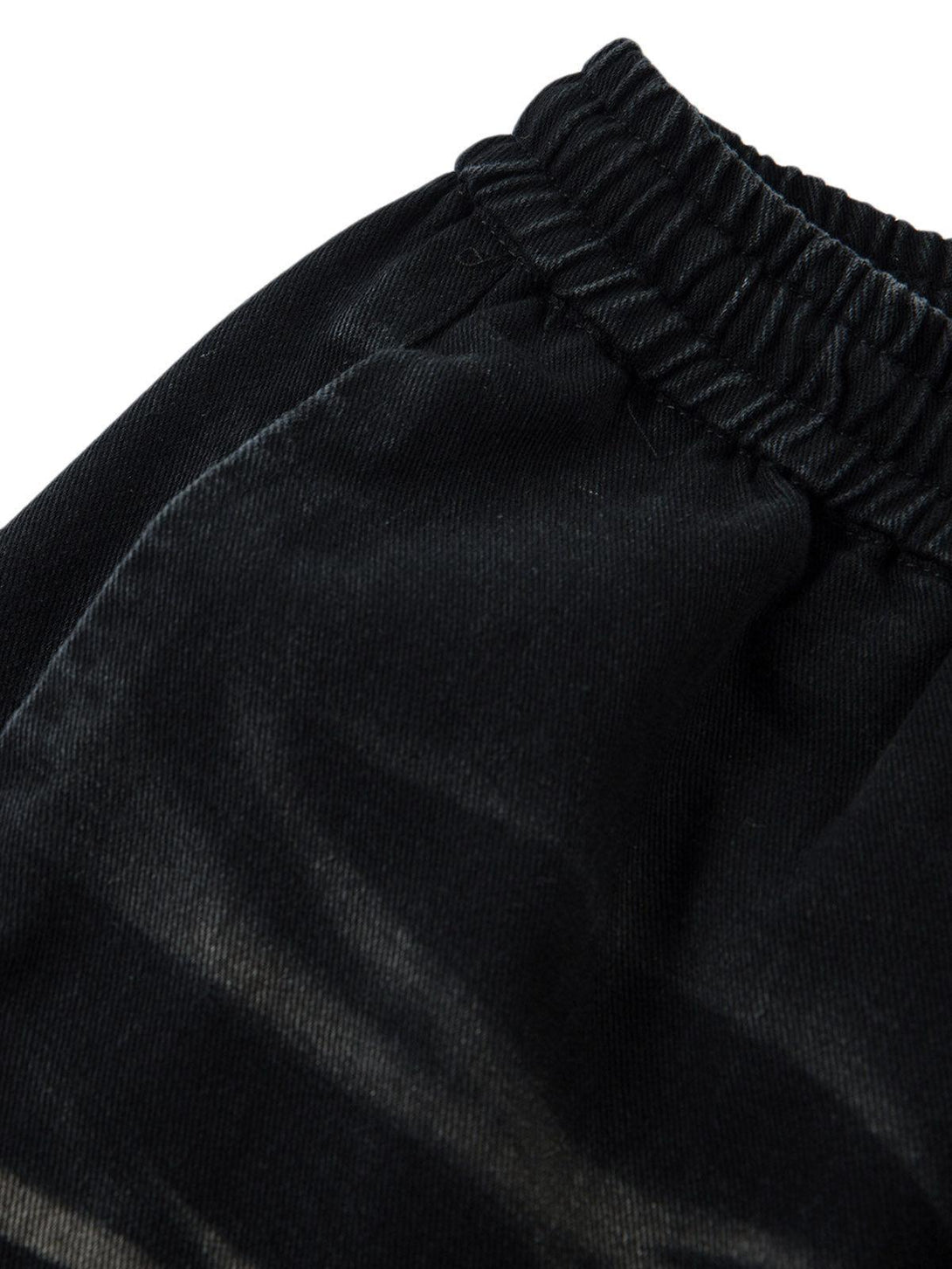 Intricate look at the elastic waistband of TALISHKO's washed cargo jeans, emphasizing texture.