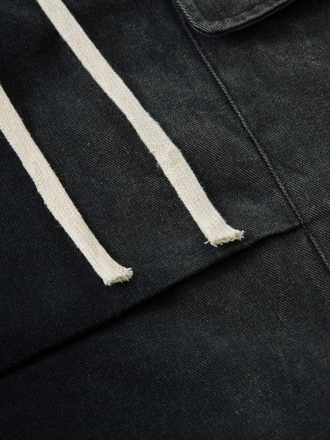 Zoomed-in texture of TALISHKO's washed cargo jeans, showcasing drawstring and fabric detail.