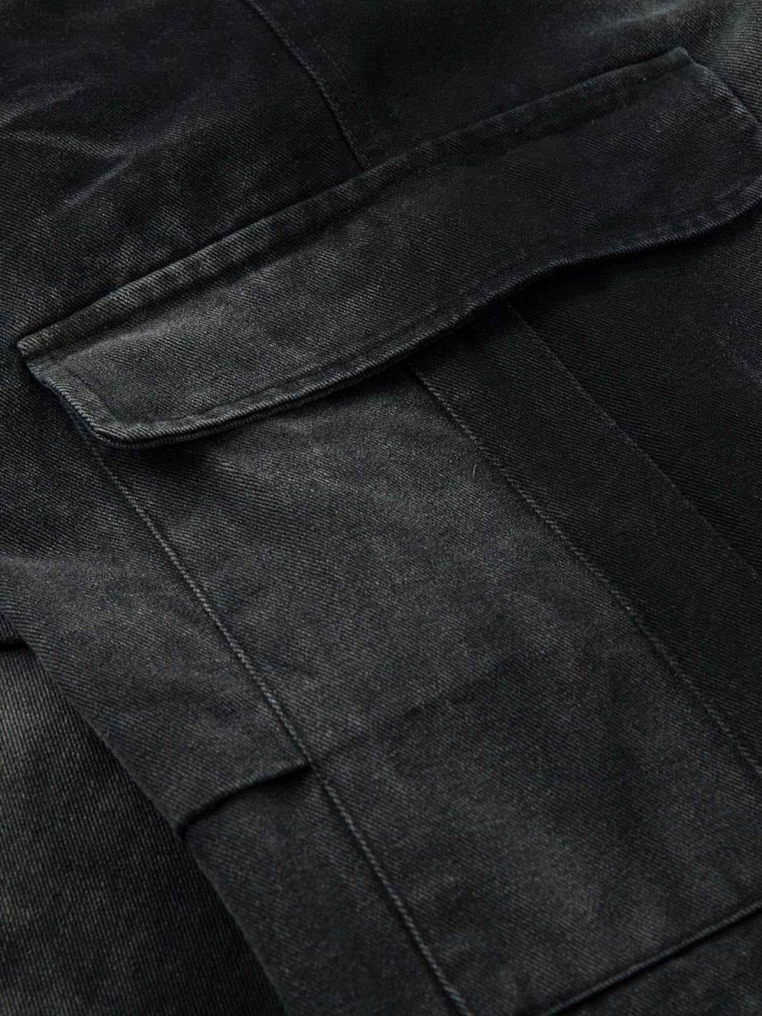 A detailed view of the pocket design on TALISHKO's washed cargo jeans, highlighting texture.