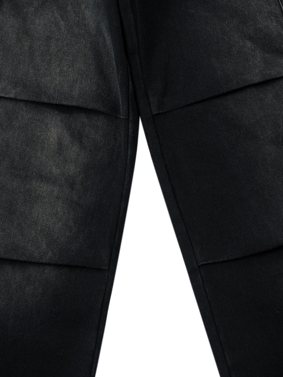 Detailed fabric and stitching on TALISHKO's washed cargo jeans, highlighting texture and design.