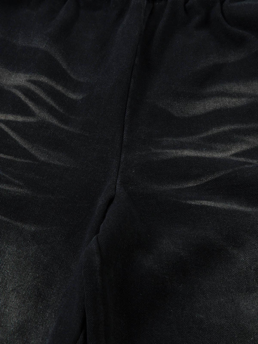 A tight crop highlighting TALISHKO's washed cargo jeans, emphasizing fabric texture.