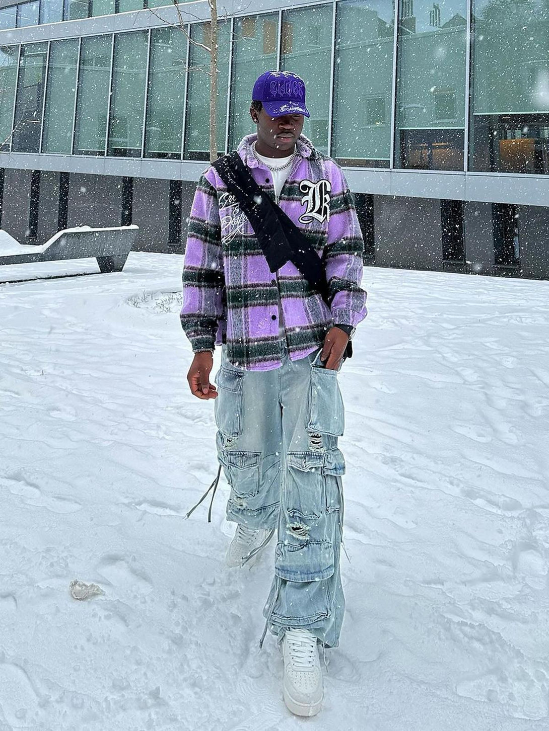 Model wearing TALISHKO washed multi-pocket cargo jeans in a snowy urban setting.