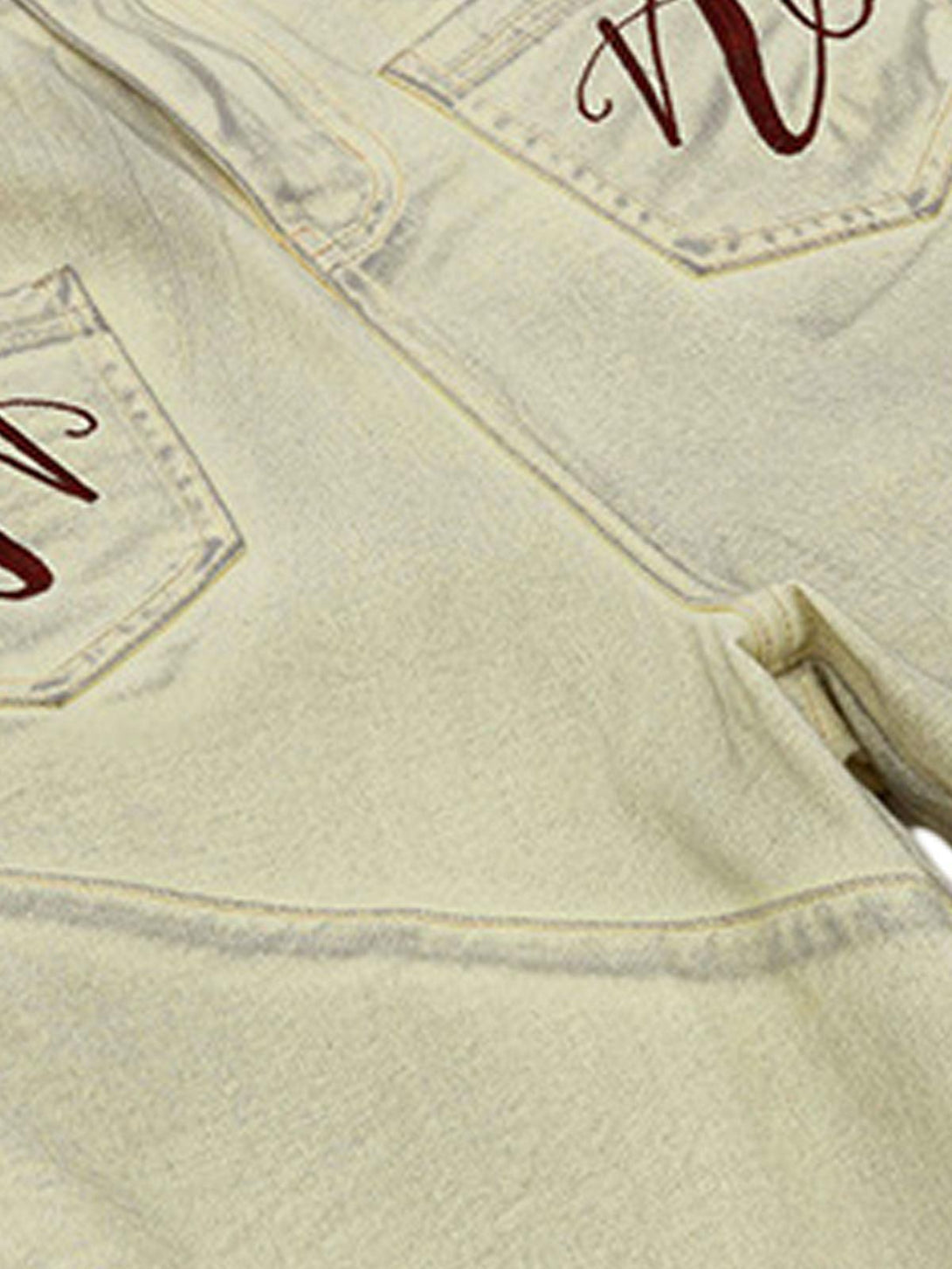 Intricate look at TALISHKO washed print baggy denim shorts, highlighting pocket embroidery.