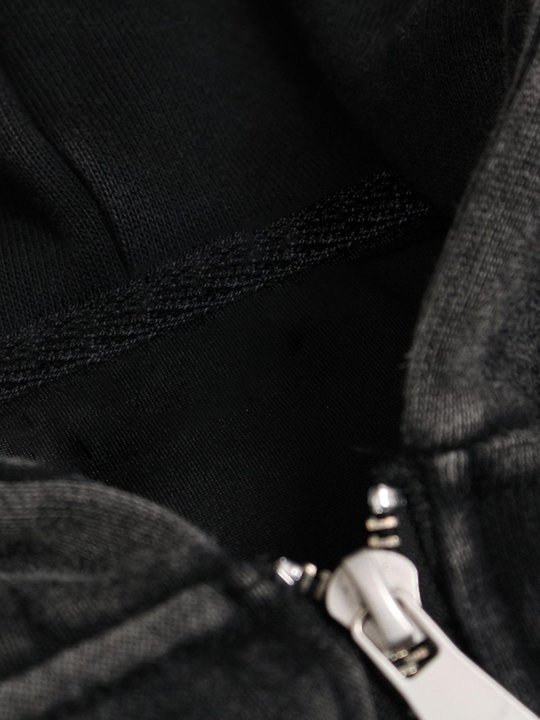 Intricate look at TALISHKO's washed racing hoodie, focusing on zipper detail and fabric texture.