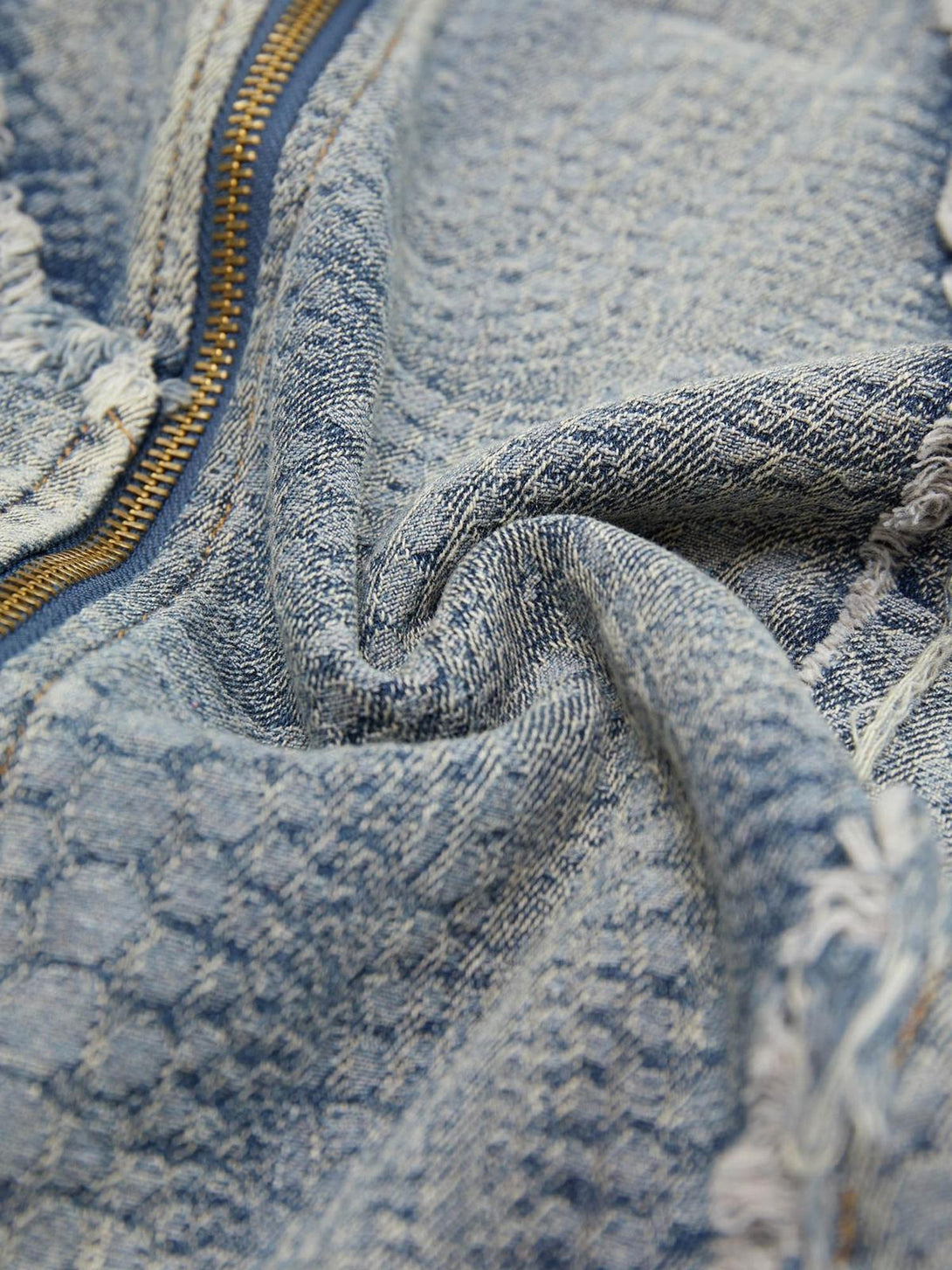 Detailed fabric and raw edge texture of a TALISHKO denim shirt, showcasing unique design elements.