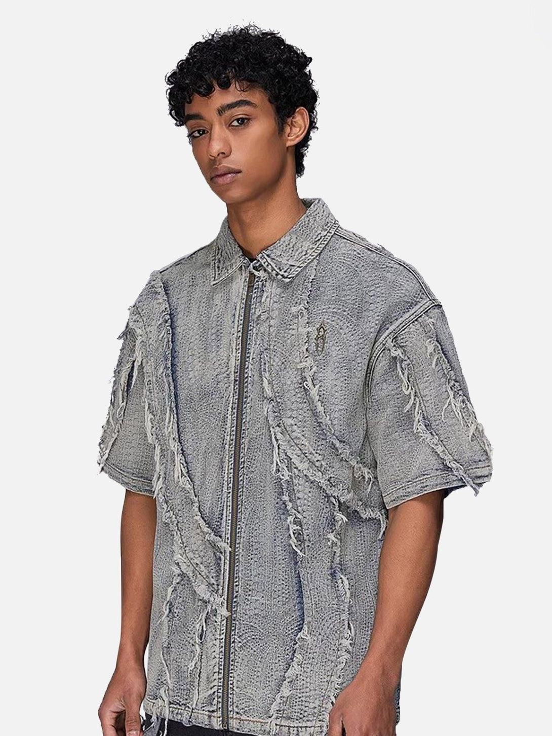 Model in a TALISHKO washed denim shirt, featuring raw edges and textured design elements.