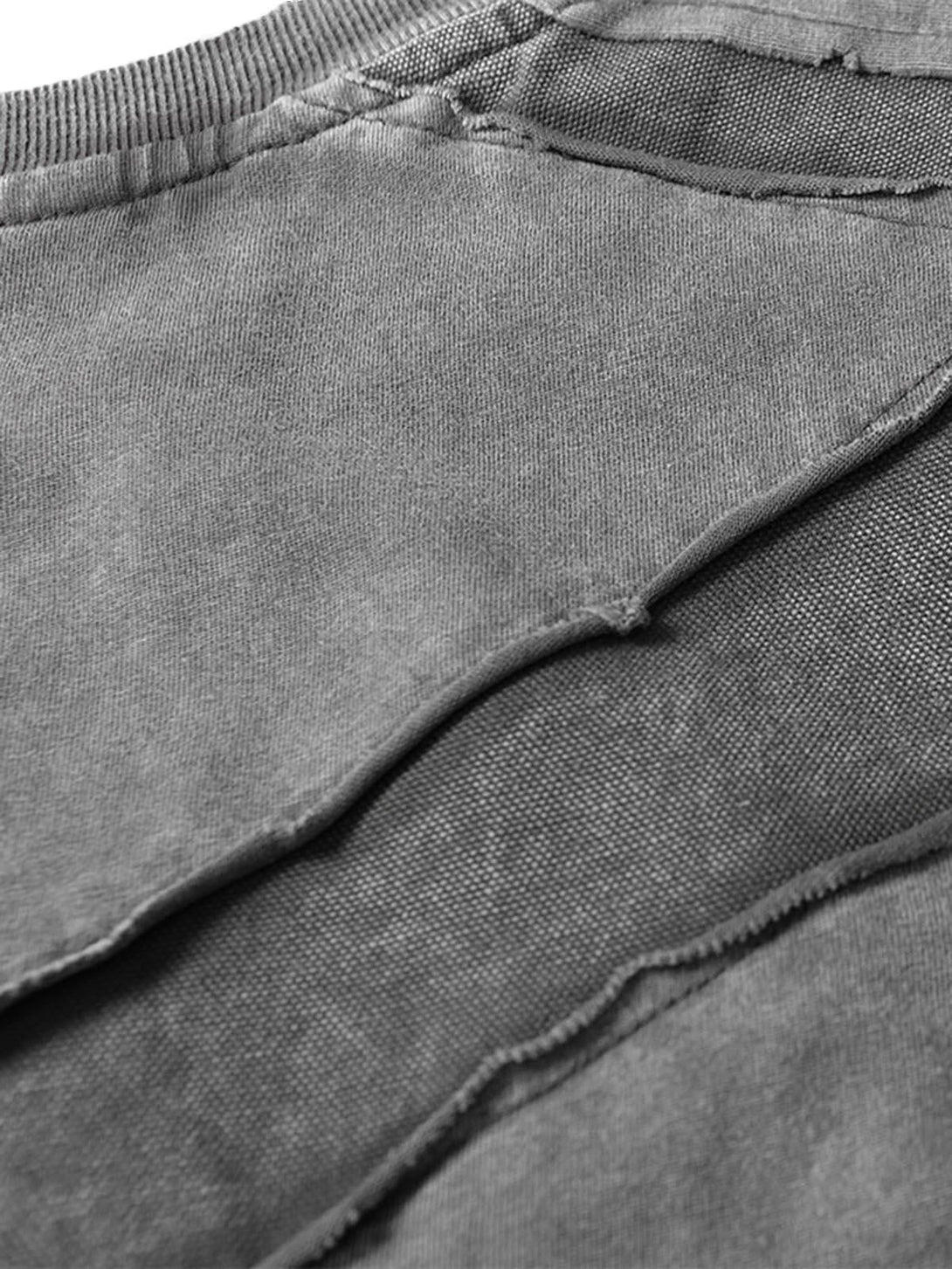 Intricate texture and raw edge details of TALISHKO's oversized T-shirt fabric.