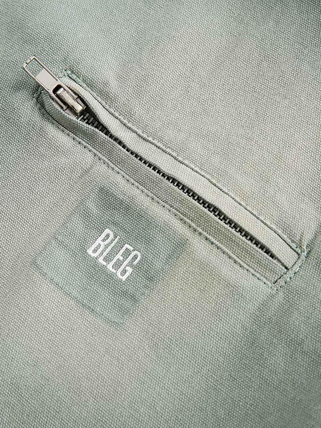 Detailed view of TALISHKO's washed work jacket zipper, showcasing texture and craftsmanship.