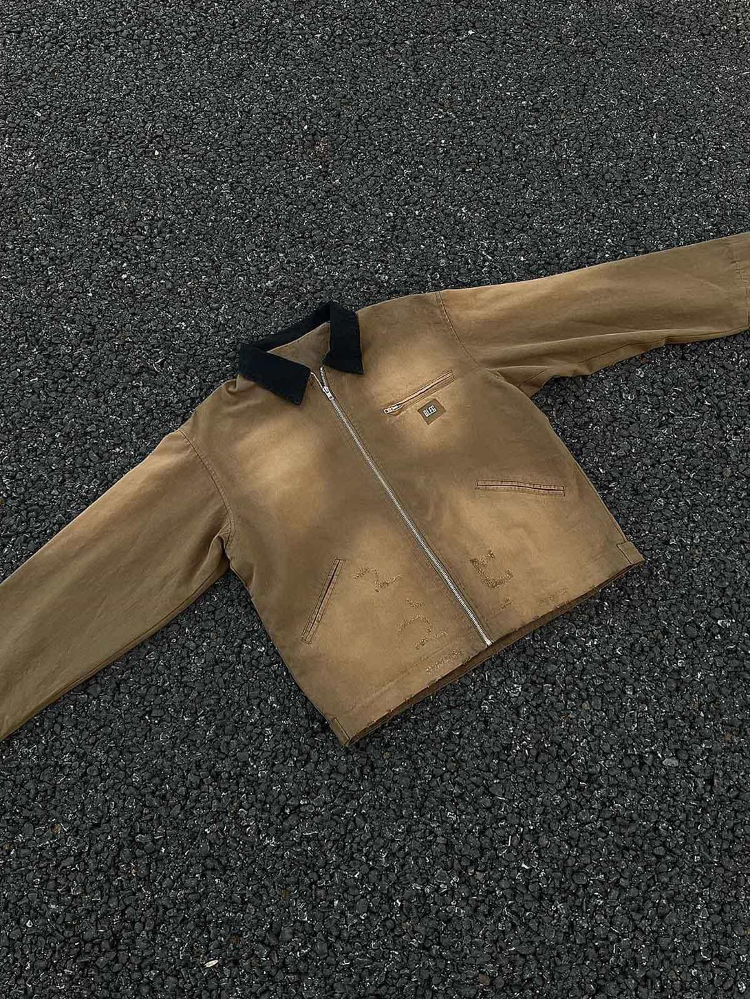 TALISHKO's washed ripped gradient zip-up work jacket laid flat, showcasing its rugged style.