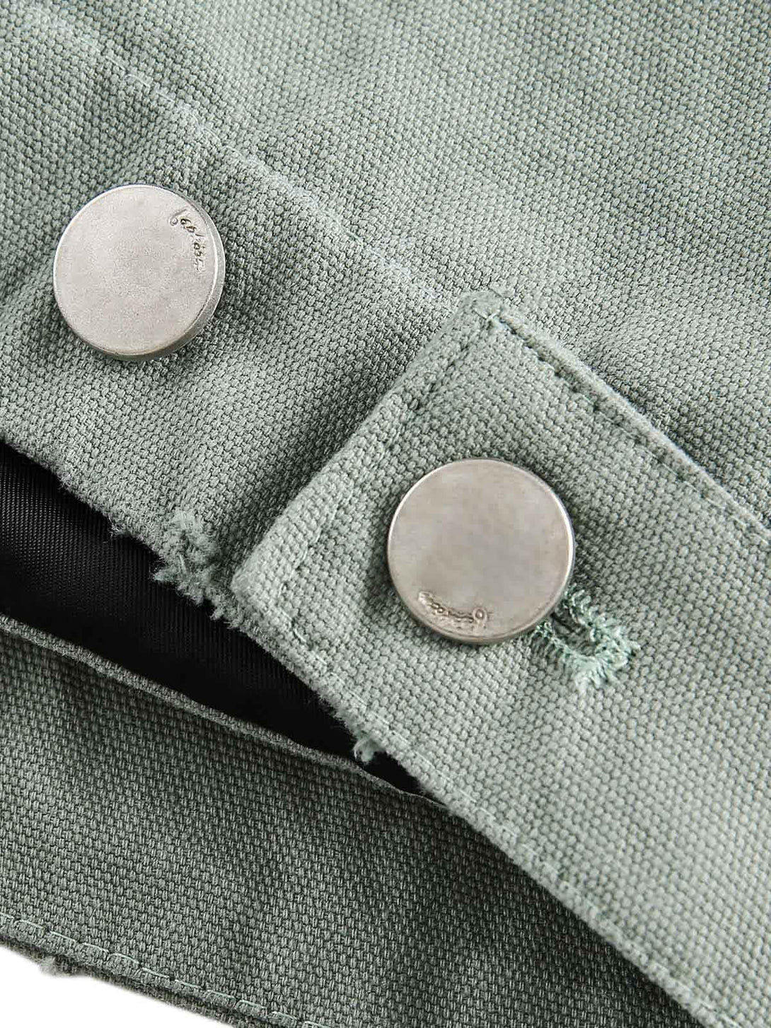 A close-up of TALISHKO's washed work jacket buttons, showcasing the rugged texture and design.