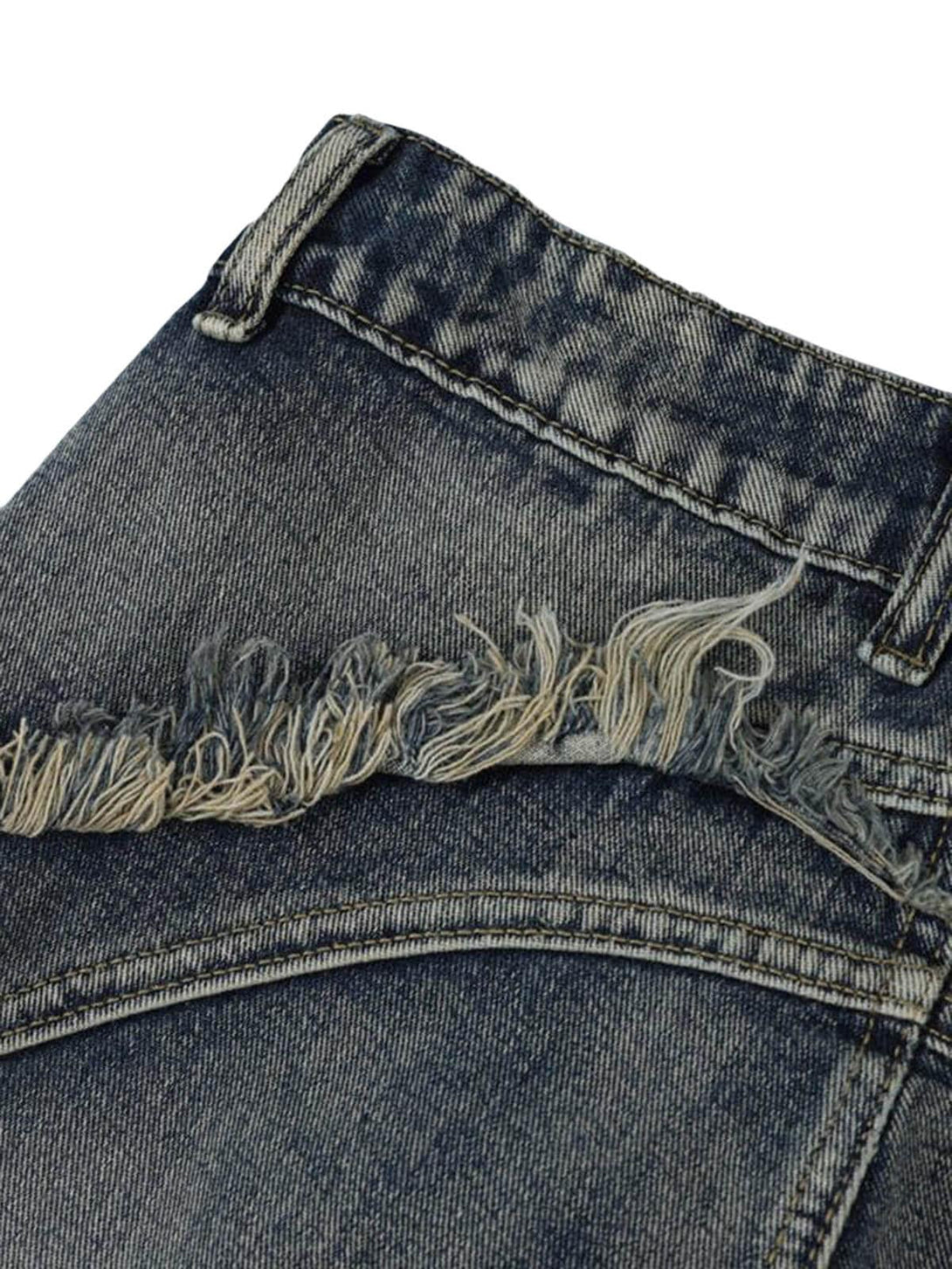 A tight crop highlighting the raw edge detail on TALISHKO washed baggy jeans.