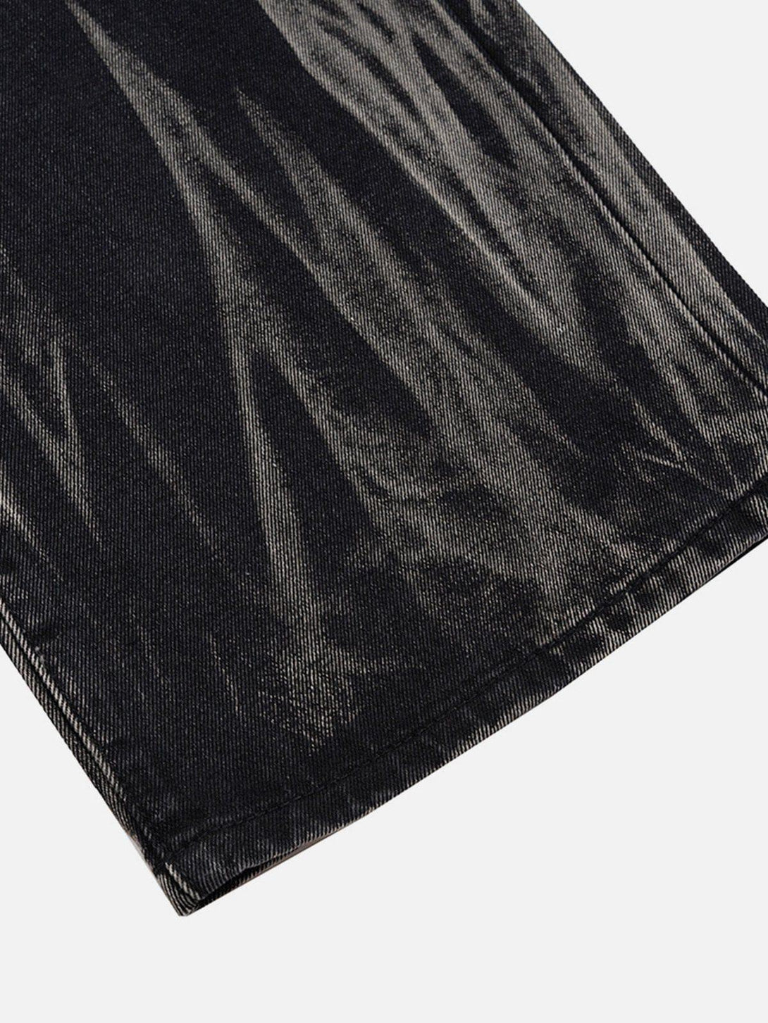 Intricate look at the washed stained texture of TALISHKO wide-leg jeans, highlighting unique design.