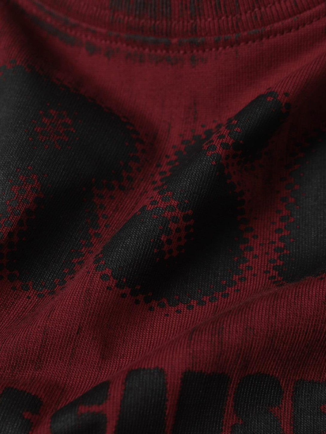 Detailed fabric and stitching of TALISHKO's Wasteland Dirty Dye T-shirt, highlighting bold red and black patterns.
