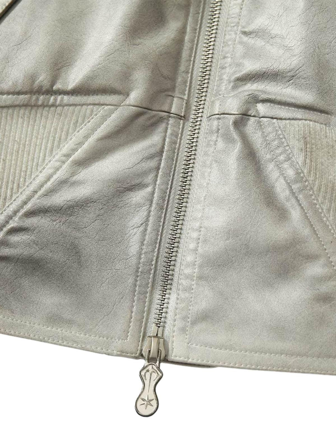 Intricate stitching and zip detail on TALISHKO's leather bomber jacket, showcasing unique texture.