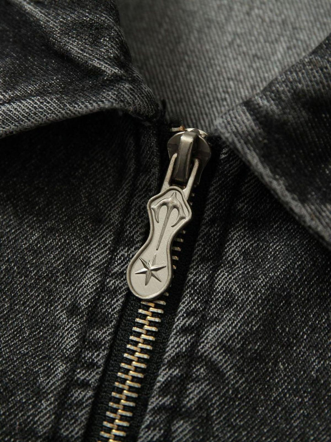 A close-up of TALISHKO denim jacket zipper, highlighting intricate metal detailing and texture.