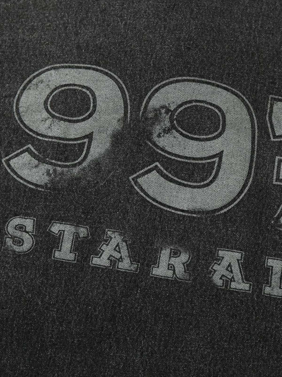 A detailed view of TALISHKO denim jacket's bold "99" embroidery, highlighting its textured style.