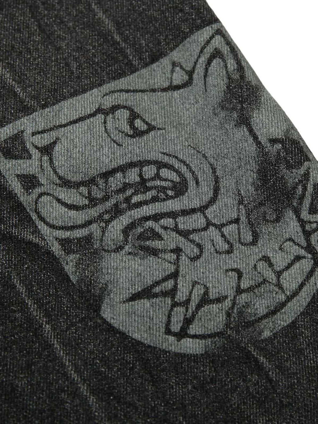 Detailed texture and design of TALISHKO denim jacket, featuring bold embroidery and rugged style.