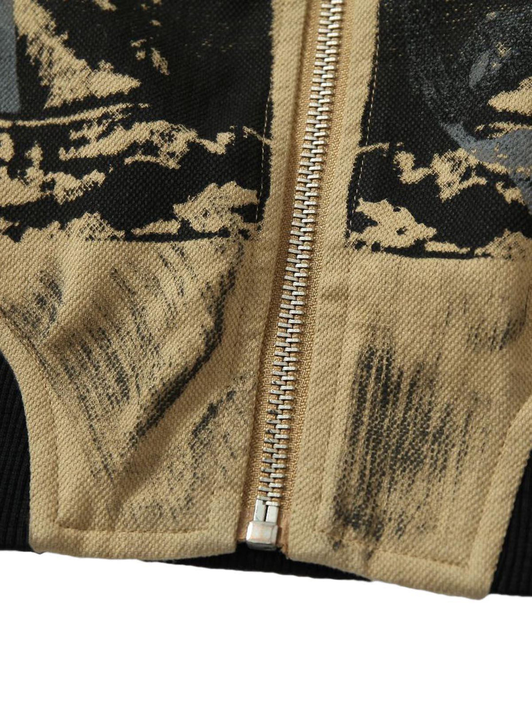 Focusing on the zipper detail of TALISHKO's jacket, showcasing its patchwork graffiti design.