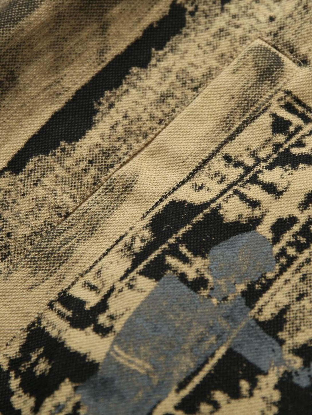 Intricate look at TALISHKO's jacket fabric, highlighting patchwork textures and graffiti design.