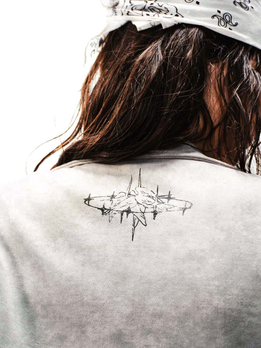 Back view of TALISHKO's jacket with intricate graffiti detail, paired with a patterned bandana.