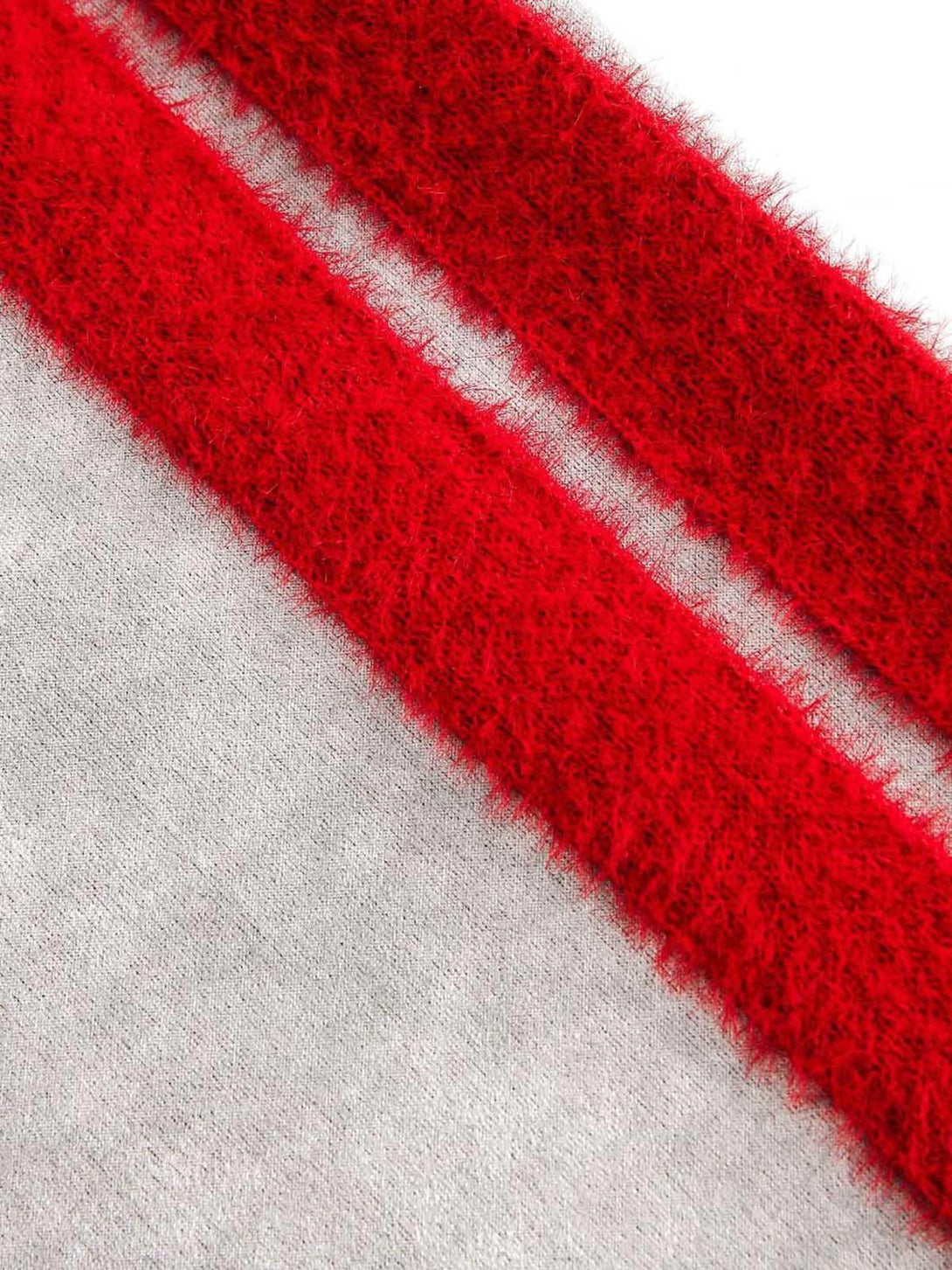 Zoomed-in texture of TALISHKO's patchwork jacket showcasing plush red stripes on gray fabric.