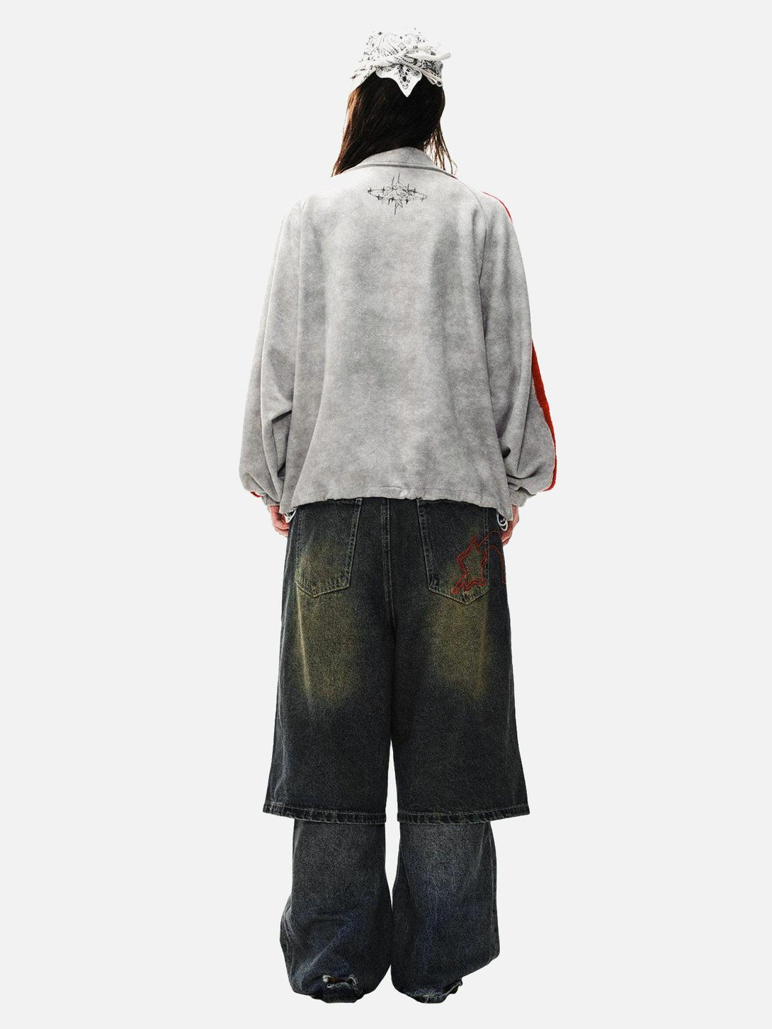 Back view of TALISHKO's streetwear ensemble with graffiti-detail jacket and loose denim pants.