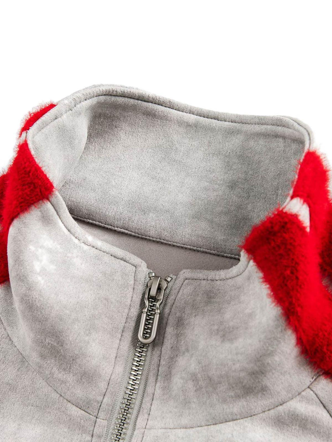Focusing on the collar and zipper detail of TALISHKO's patchwork graffiti zip-up jacket.