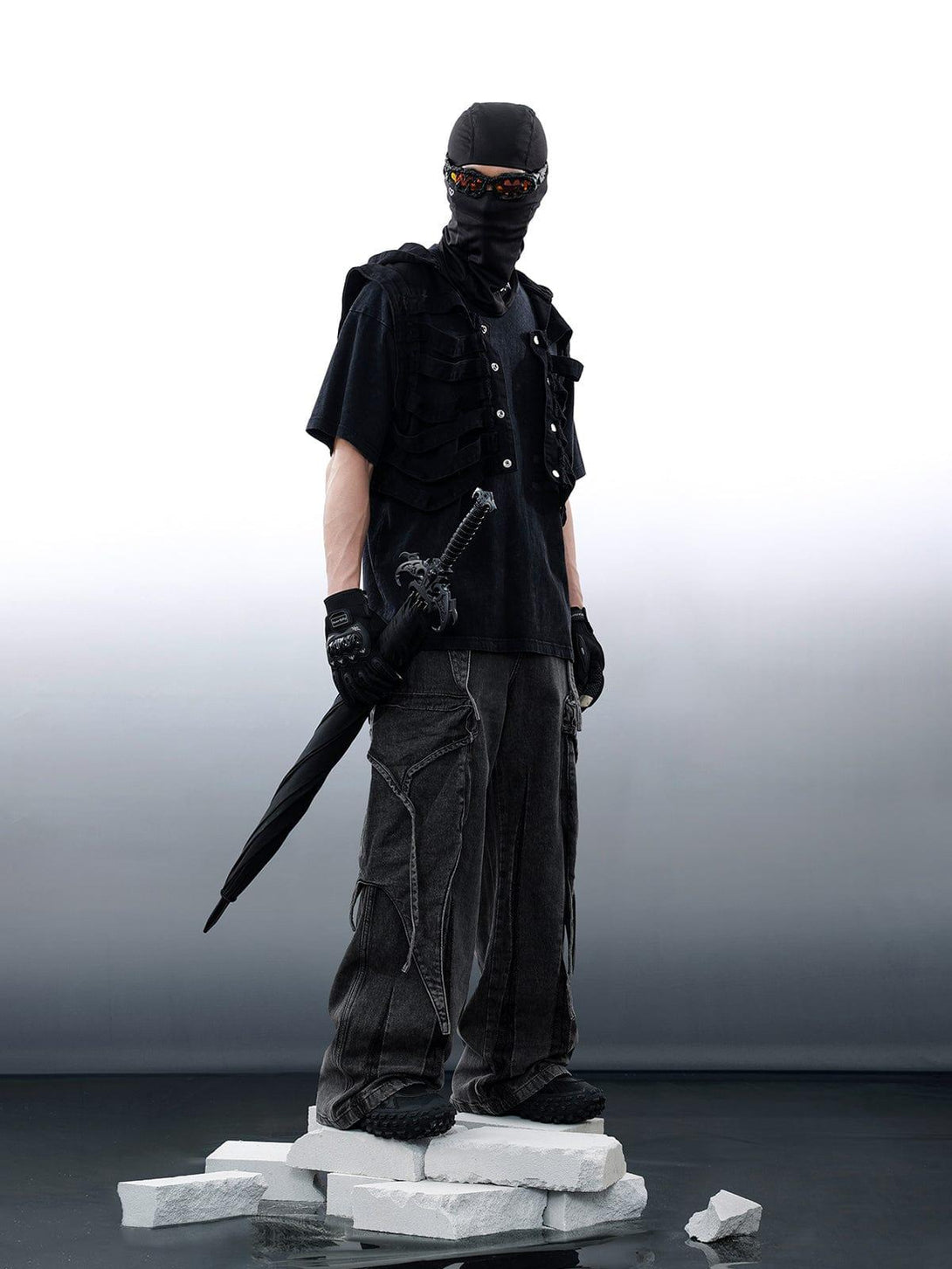 Model wearing TALISHKO wasteland punk ensemble with washed wide-leg jeans and tactical vest.