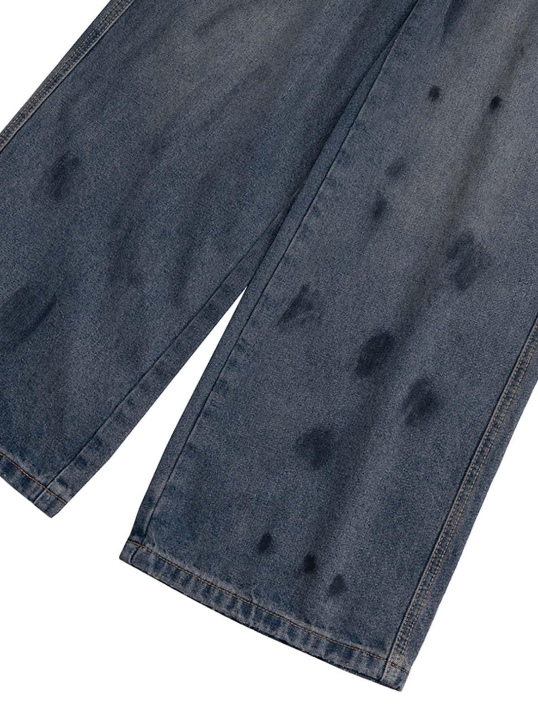 Detailed look at TALISHKO's ink splash design on baggy jeans, highlighting unique texture.