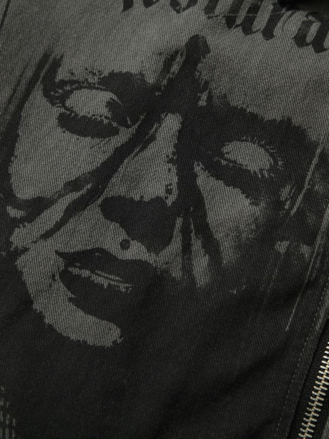 A close-up of TALISHKO's barn jacket featuring a striking black and gray portrait print design.