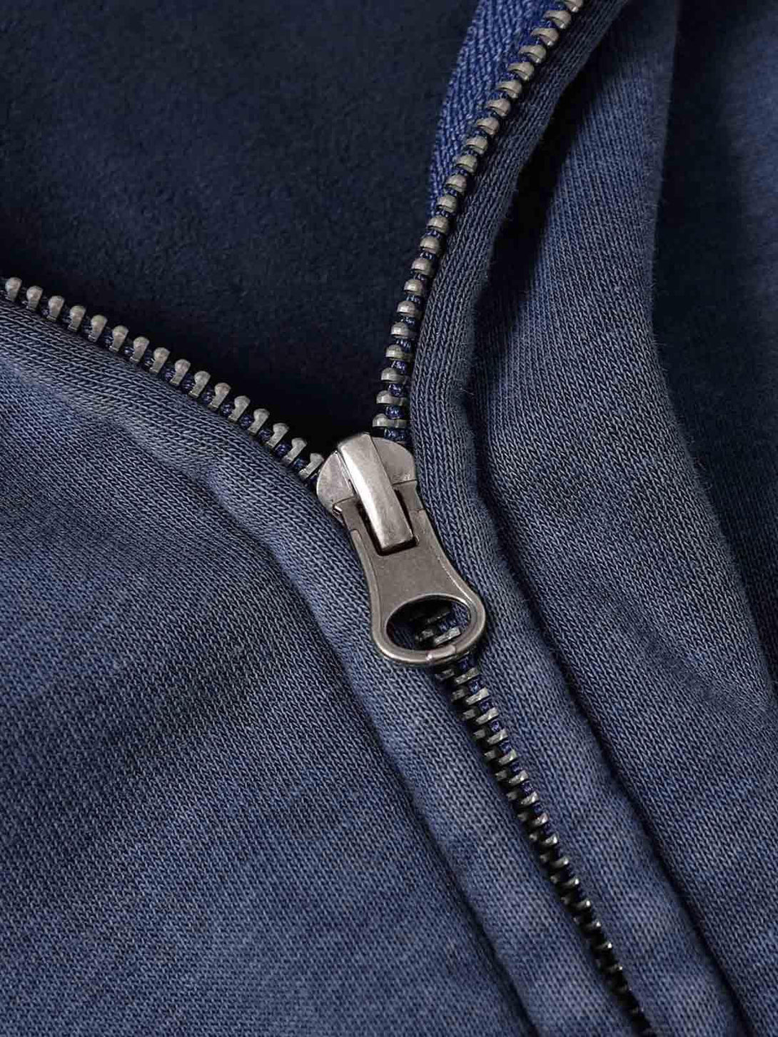 Focusing on the zipper detail of TALISHKO's washed sweatshirt, showcasing its rugged design.